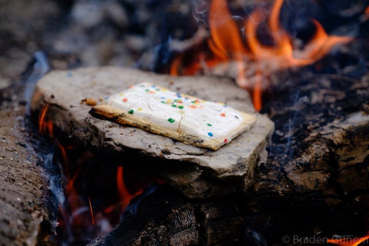 Warming a poptart in the camp fire.